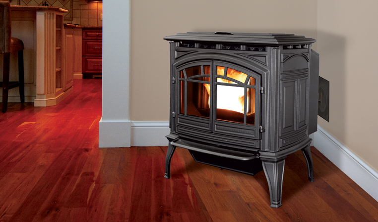 A freestanding pellet stove sitting in the corner of a room