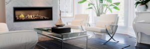 A narrow sleek, vintage fireplace lit in front of a wood fireplace