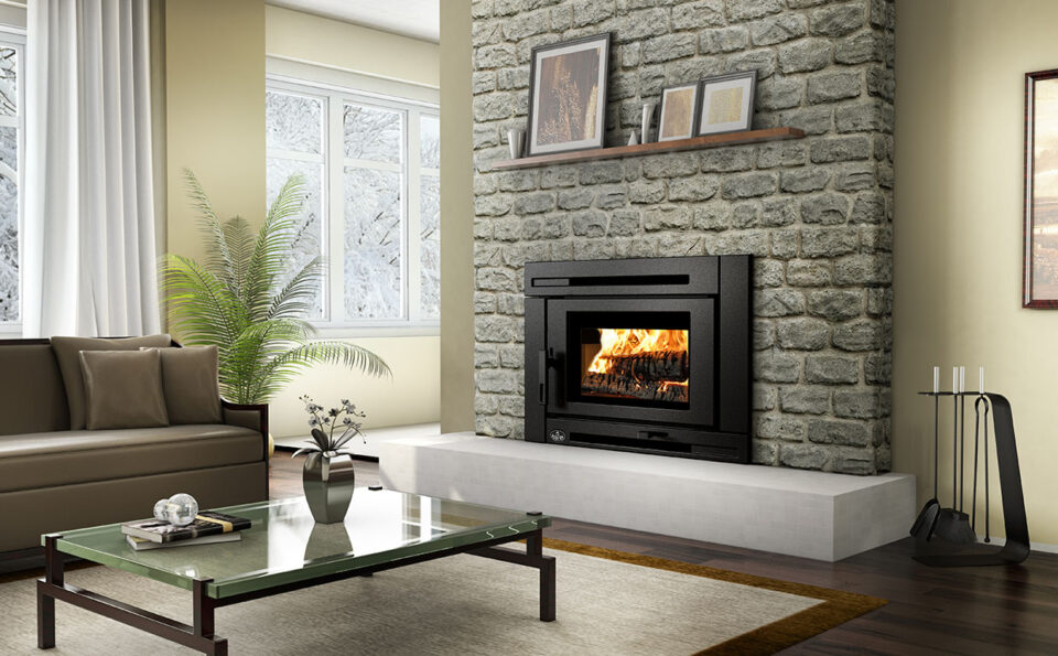 Cozy living room with a stone fireplace, beige sofa, and snowy view through large windows